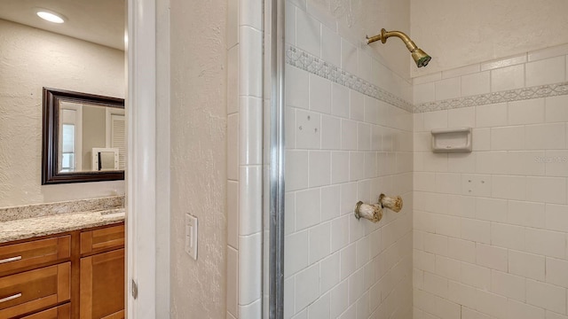 bathroom featuring vanity and an enclosed shower