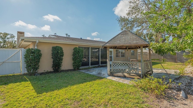 back of property with a lawn and a patio