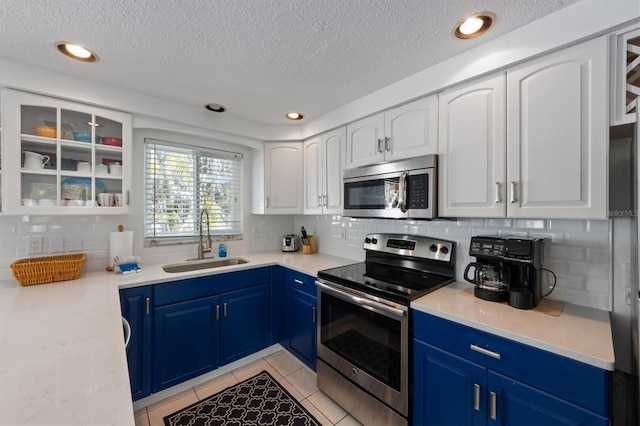 kitchen with blue cabinetry, white cabinetry, stainless steel appliances, and sink