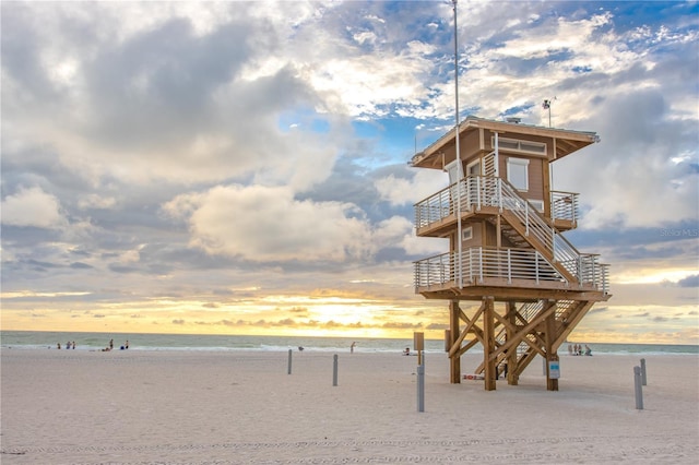 surrounding community with a water view and a view of the beach