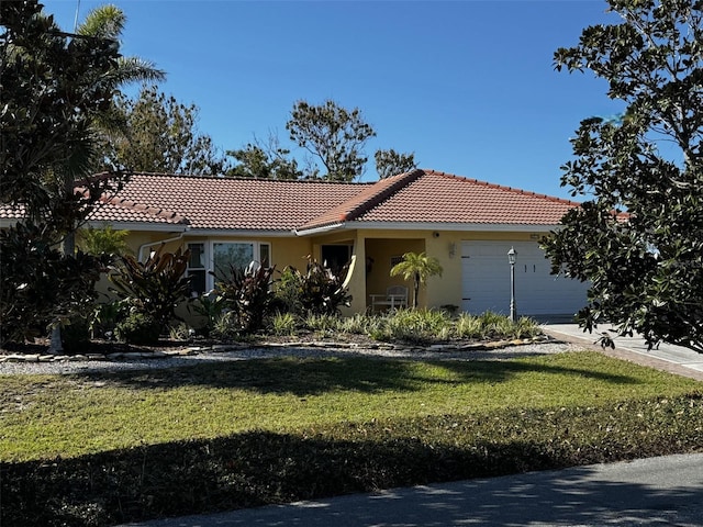 view of front of property featuring an attached garage, a tiled roof, driveway, stucco siding, and a front lawn