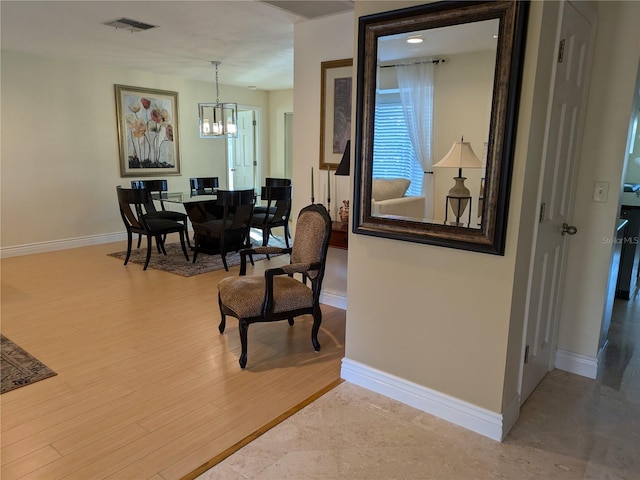 sitting room featuring a notable chandelier, wood finished floors, visible vents, and baseboards