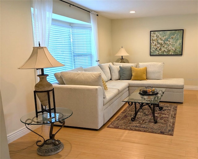 living area with baseboards, wood finished floors, and recessed lighting