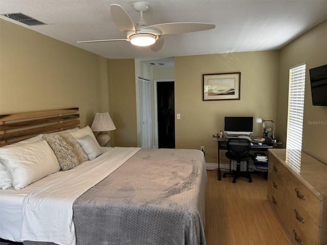 bedroom with a ceiling fan, a closet, visible vents, and light wood finished floors