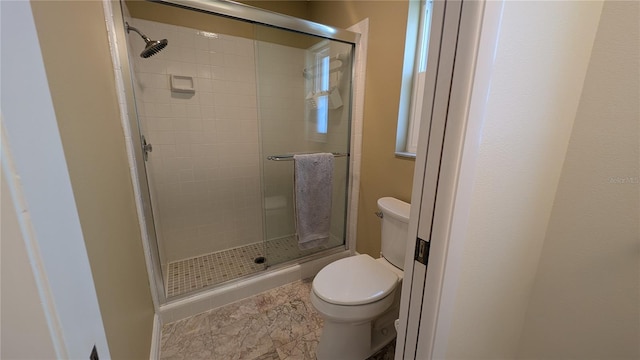 bathroom featuring toilet and a stall shower