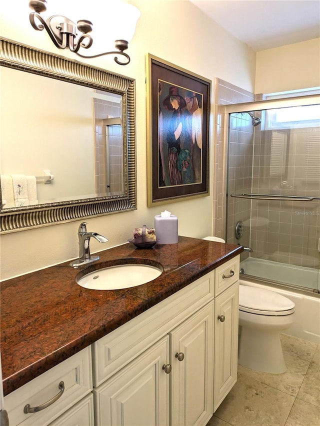 bathroom featuring toilet, tile patterned flooring, combined bath / shower with glass door, and vanity