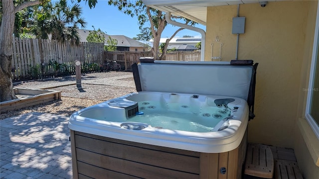 view of patio with fence private yard and a hot tub