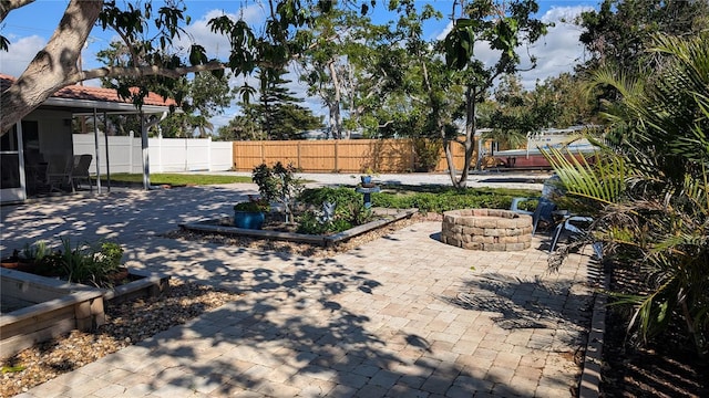 view of yard featuring a fire pit, a patio area, and a fenced backyard