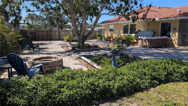 view of yard with an outdoor fire pit, a patio area, a hot tub, and a fenced backyard