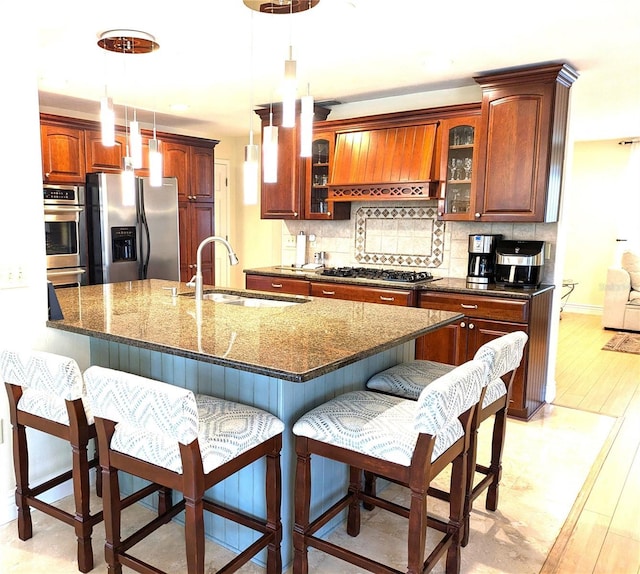 kitchen featuring stainless steel appliances, premium range hood, backsplash, and a kitchen bar