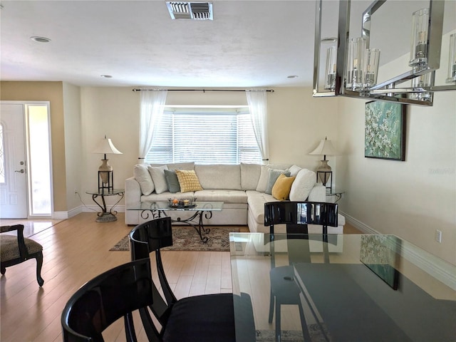 living room with visible vents, baseboards, and wood finished floors