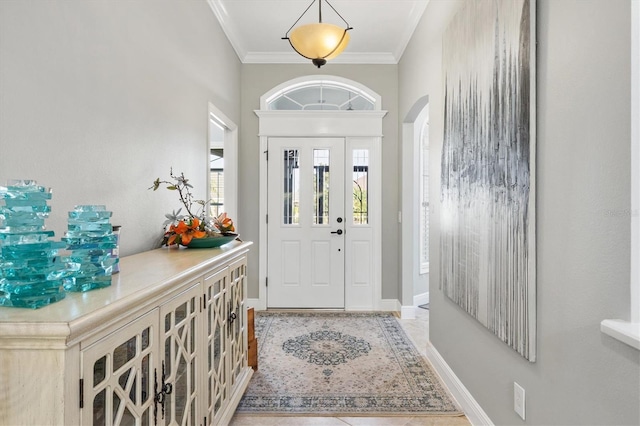 foyer with ornamental molding and light tile patterned flooring