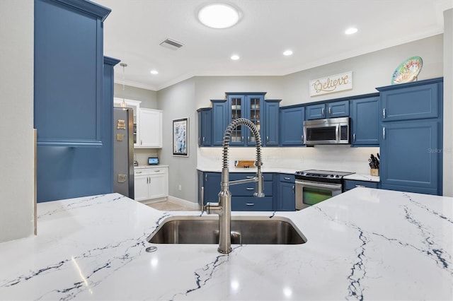 kitchen featuring light stone countertops, appliances with stainless steel finishes, sink, and blue cabinetry