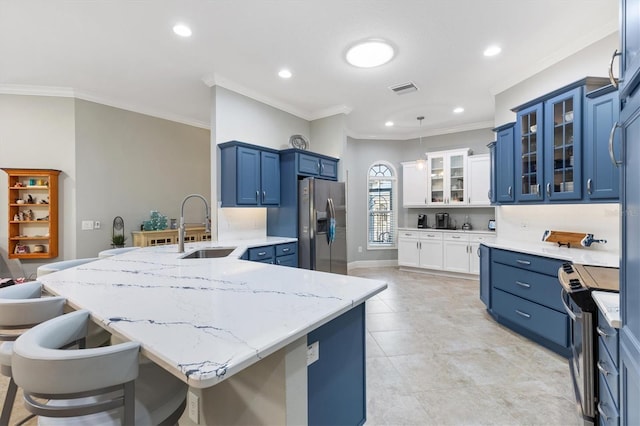 kitchen with stainless steel appliances, a breakfast bar, sink, and blue cabinetry