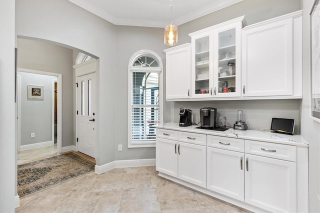 bar featuring pendant lighting, white cabinetry, ornamental molding, light tile patterned floors, and light stone countertops