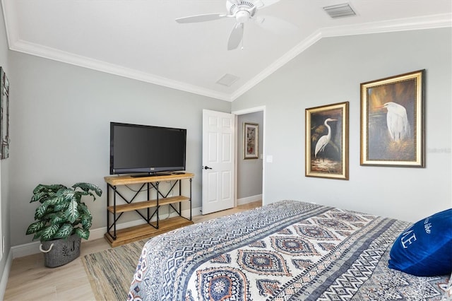 bedroom featuring ceiling fan, ornamental molding, vaulted ceiling, and light wood-type flooring