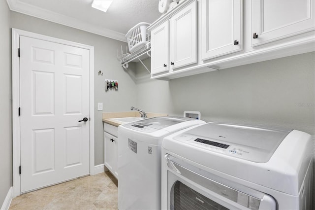 washroom with sink, crown molding, light tile patterned floors, cabinets, and washer and dryer