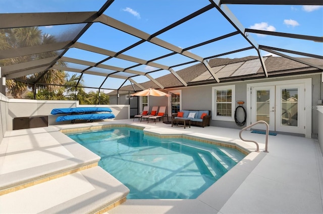 view of pool with outdoor lounge area, a lanai, a patio area, and french doors