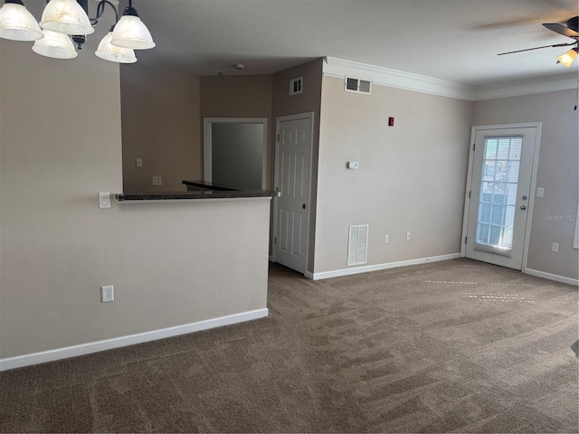 interior space with decorative light fixtures, carpet floors, ornamental molding, ceiling fan, and kitchen peninsula