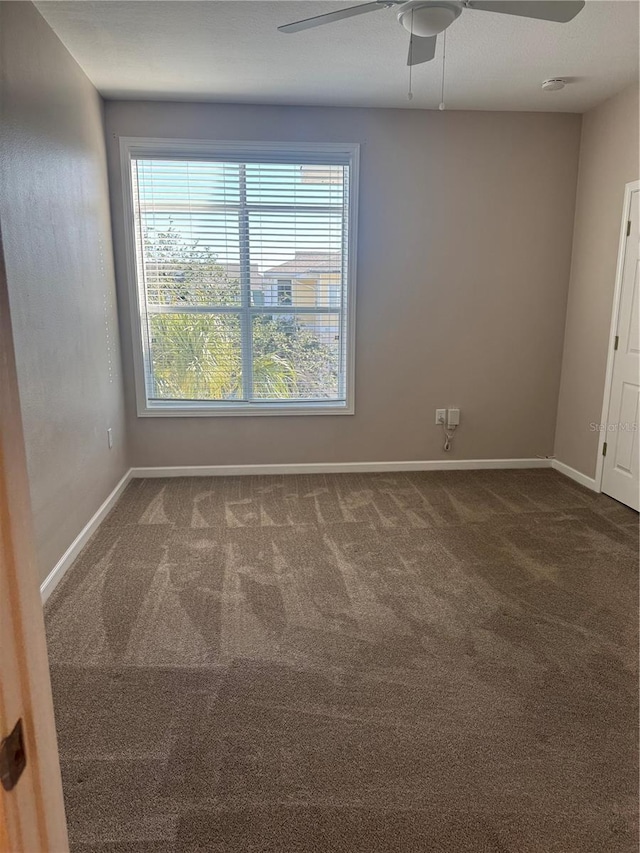 carpeted spare room with ceiling fan