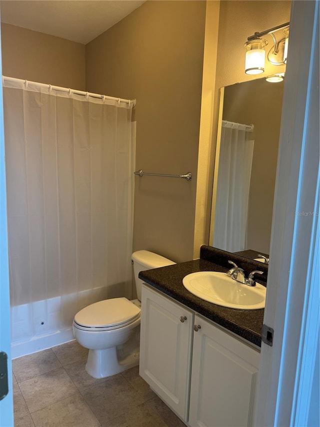 bathroom with a shower with curtain, vanity, tile patterned floors, and toilet