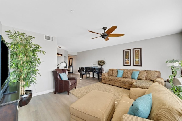 living room featuring ceiling fan and light hardwood / wood-style floors