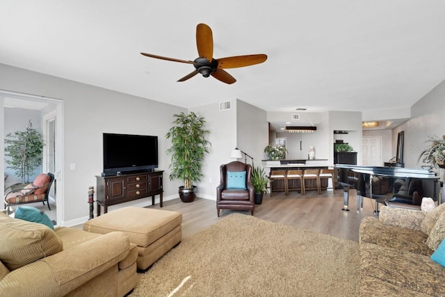 living room featuring light hardwood / wood-style flooring and ceiling fan