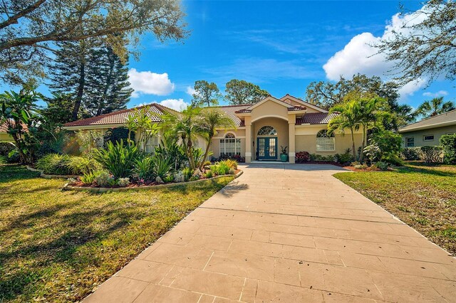 mediterranean / spanish home featuring french doors and a front yard