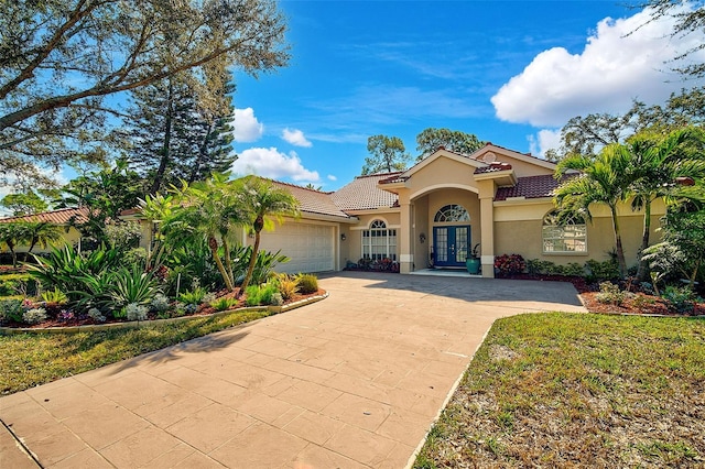 mediterranean / spanish home with a garage and french doors