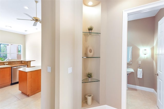 interior space with light tile patterned floors, recessed lighting, a sink, and baseboards