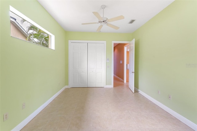 unfurnished bedroom featuring light tile patterned floors, a closet, visible vents, and baseboards