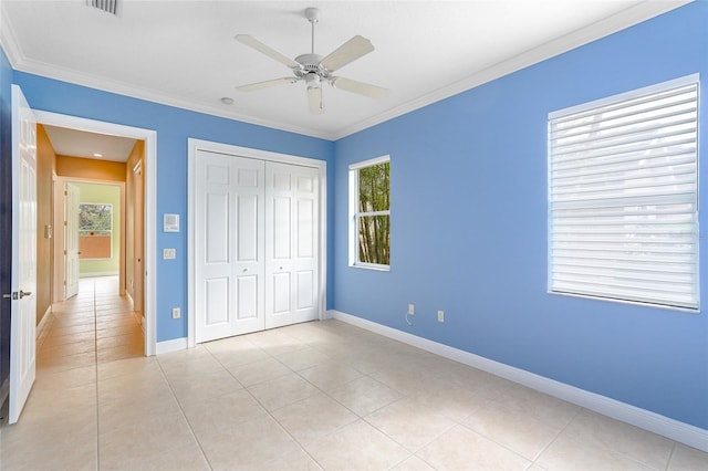 unfurnished bedroom featuring a closet, multiple windows, and crown molding