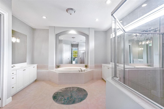 bathroom featuring tile patterned floors, vanity, a shower stall, a bath, and recessed lighting