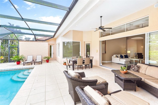 outdoor pool featuring glass enclosure, outdoor dining area, an outdoor living space, a ceiling fan, and a patio area