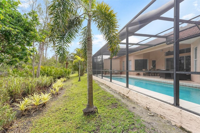 pool with a lanai, a patio area, and a yard