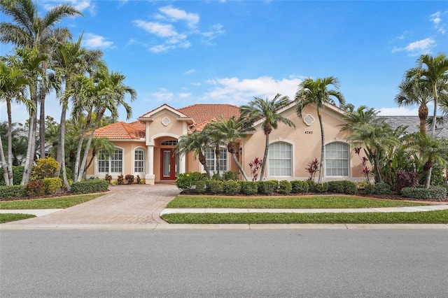 mediterranean / spanish-style home with a tile roof and stucco siding