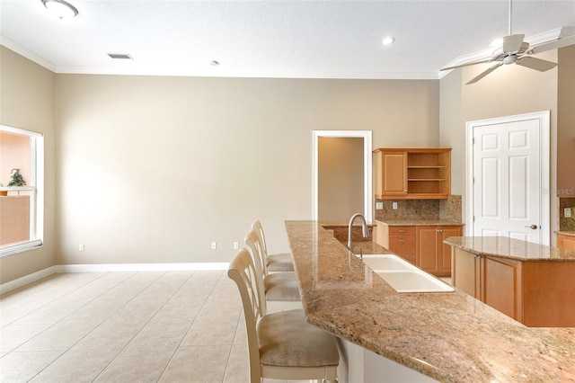 kitchen with crown molding, a sink, open shelves, and a kitchen island