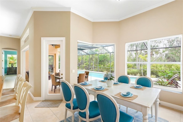 dining room with ornamental molding, a sunroom, a healthy amount of sunlight, and light tile patterned floors