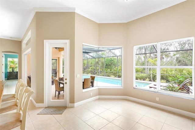 interior space with ornamental molding, light tile patterned flooring, a sunroom, and baseboards