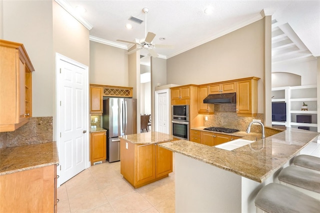 kitchen featuring light tile patterned floors, appliances with stainless steel finishes, ornamental molding, a sink, and under cabinet range hood