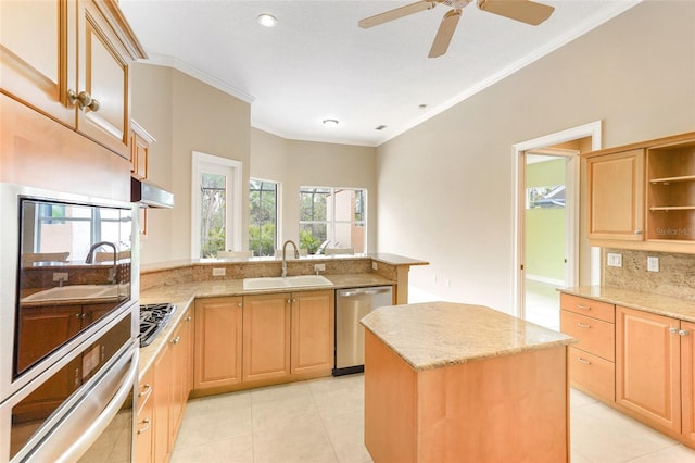 kitchen featuring a peninsula, light stone countertops, stainless steel appliances, and a sink