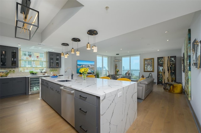 kitchen featuring a large island, sink, pendant lighting, wine cooler, and stainless steel dishwasher