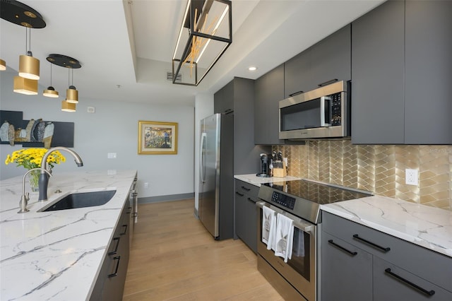 kitchen featuring gray cabinets, appliances with stainless steel finishes, sink, and decorative light fixtures