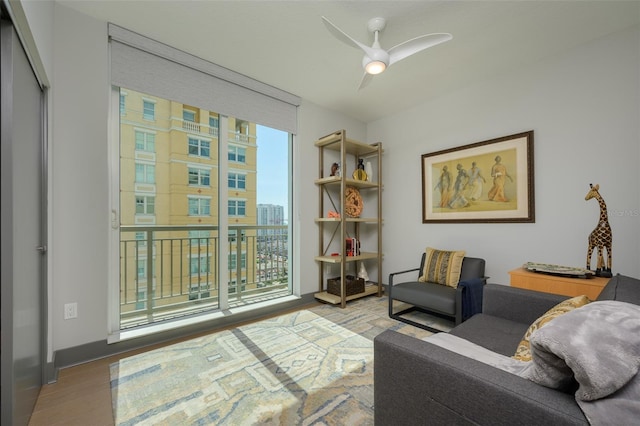 living area with hardwood / wood-style floors, expansive windows, and ceiling fan