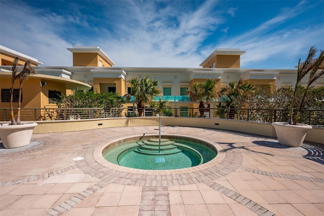 view of swimming pool featuring a community hot tub and a patio