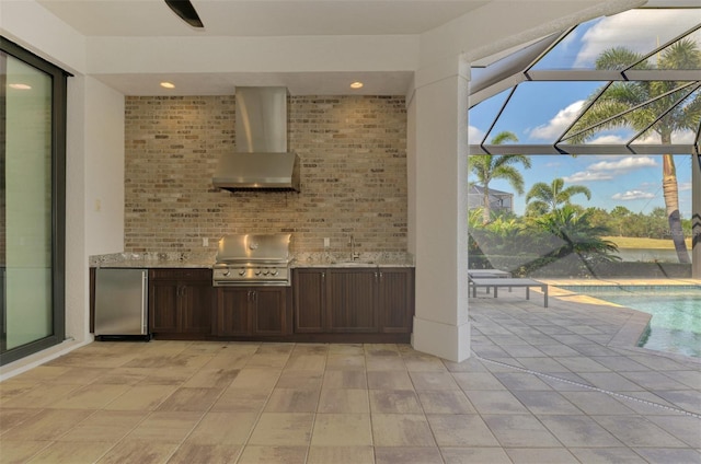 bar featuring refrigerator, light tile patterned floors, a sunroom, a sink, and wall chimney range hood