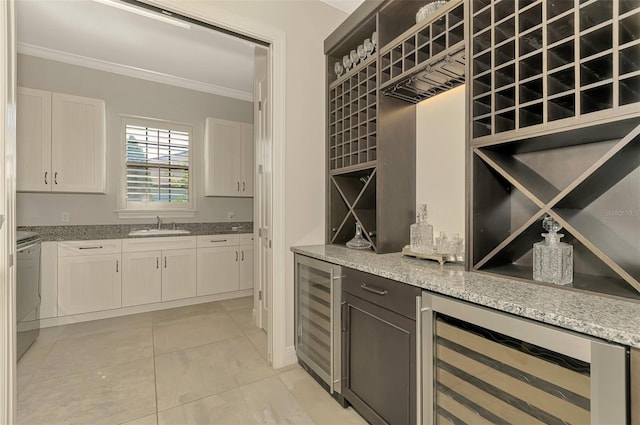 wine cellar with a bar, beverage cooler, ornamental molding, and a sink