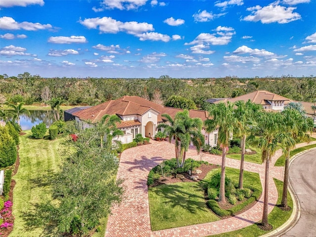 view of front of home with a front yard, decorative driveway, a tile roof, and stucco siding