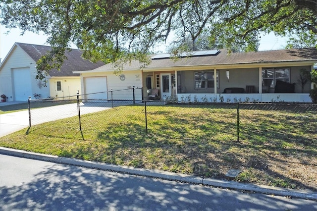 ranch-style home with a garage, a front yard, and solar panels