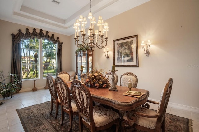 dining room with light tile patterned floors, a tray ceiling, visible vents, and baseboards